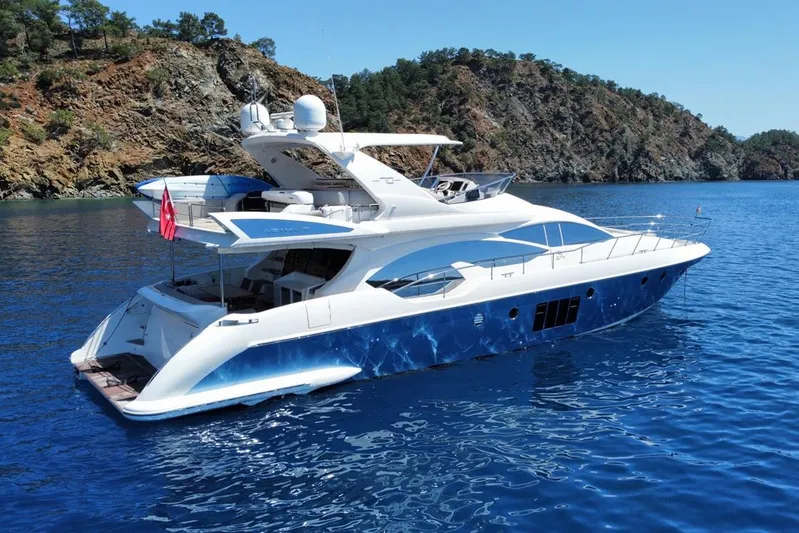  Yacht Photos Pics Luxury 2010 Azimut 70 yacht cruising in clear blue waters near rocky coastline.