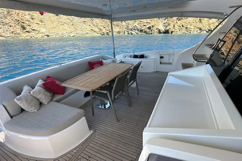  Yacht Photos Pics Luxurious 2010 Azimut 70 yacht deck with seating, table, and scenic water view.