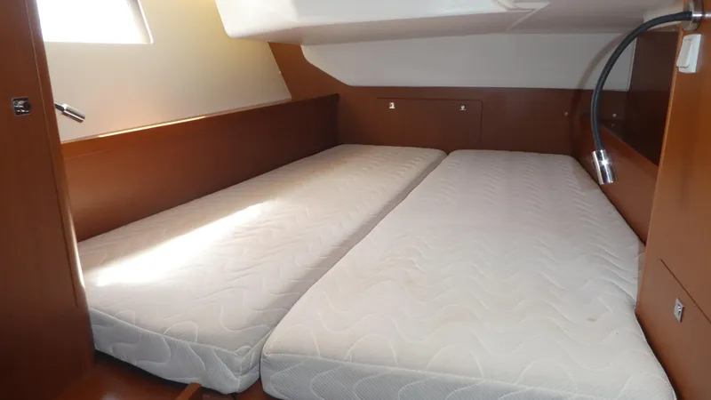  Yacht Photos Pics Cabin interior of 2014 Beneteau Oceanis 41 with twin mattresses and wooden finish.