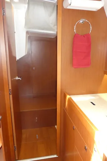  Yacht Photos Pics Interior of 2014 Beneteau Oceanis 41 yacht, featuring wooden cabinetry and a red towel.