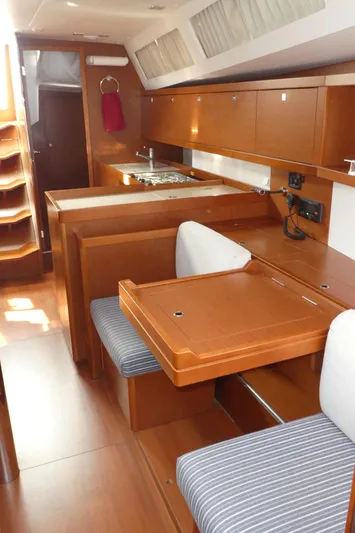  Yacht Photos Pics Interior of 2014 Beneteau Oceanis 41 sailboat with wood finish and compact kitchen area.