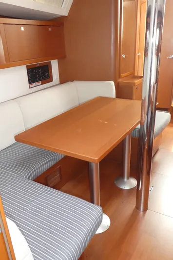  Yacht Photos Pics Interior of 2014 Beneteau Oceanis 41 sailboat with dining area and wooden table.