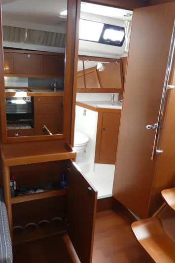  Yacht Photos Pics Interior of 2014 Beneteau Oceanis 41 sailboat, featuring wood cabinetry and compact kitchen area.