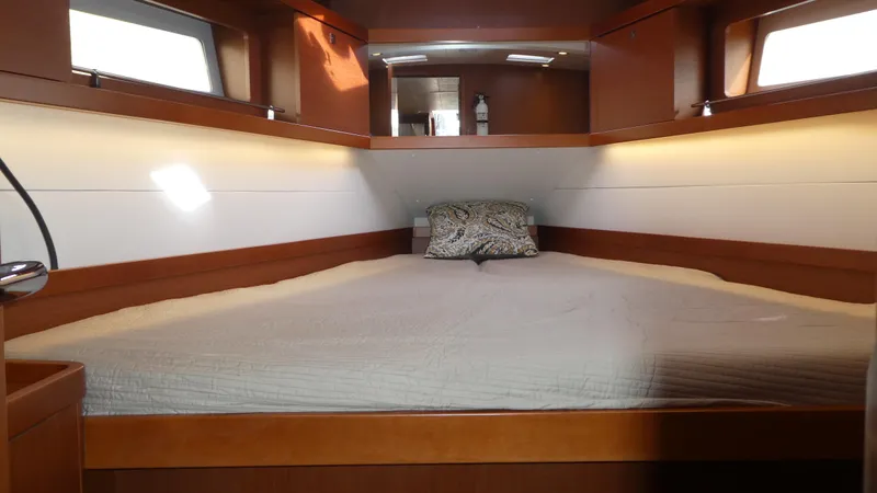  Yacht Photos Pics Cabin interior of 2014 Beneteau Oceanis 41 sailboat with cozy bed and wooden finish.