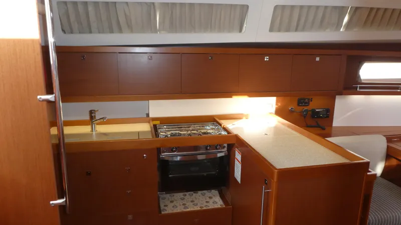  Yacht Photos Pics Interior view of 2014 Beneteau Oceanis 41 yacht kitchen with wood cabinetry and modern appliances.