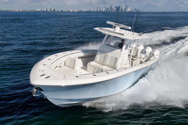  Yacht Photos Pics 2022 Invincible 39 Open Fisherman boat cruising on open water with city skyline backdrop.