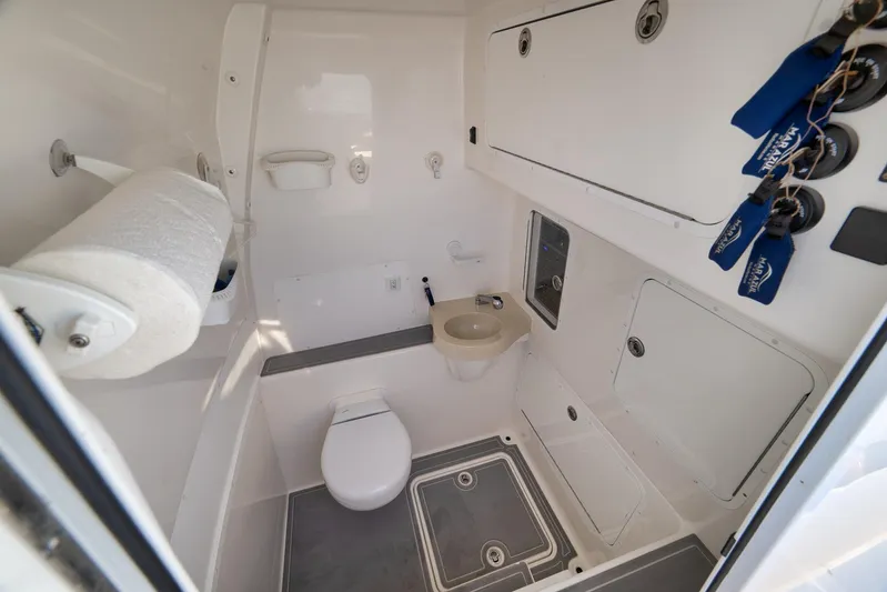  Yacht Photos Pics 2022 Invincible 39 Open Fisherman boat bathroom with toilet, sink, and storage compartments.