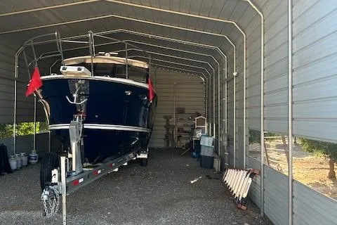  Yacht Photos Pics 2024 Cutwater C-32 C boat stored in a metal shelter on a trailer.