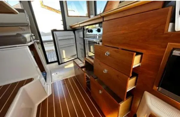  Yacht Photos Pics 2024 Cutwater C-32 C interior with open wooden cabinets and modern appliances.