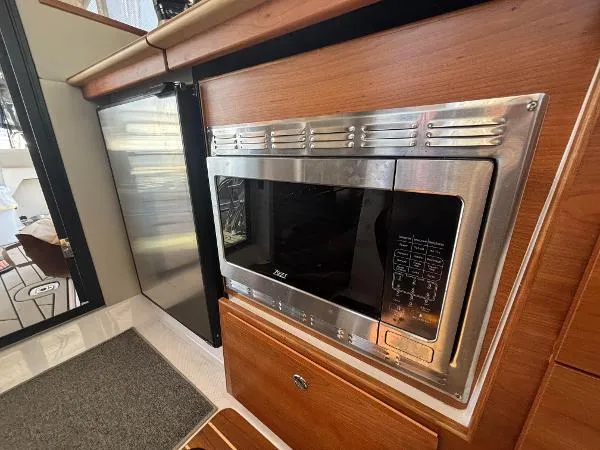  Yacht Photos Pics 2024 Cutwater C-32 C interior with stainless steel microwave and wooden cabinetry.
