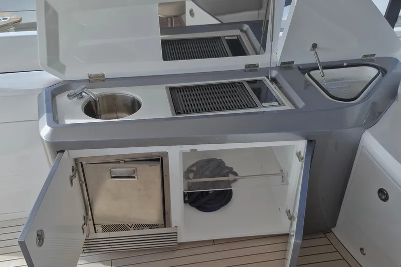  Yacht Photos Pics Outdoor kitchenette on 2024 Princess V50 yacht with sink, grill, and storage.