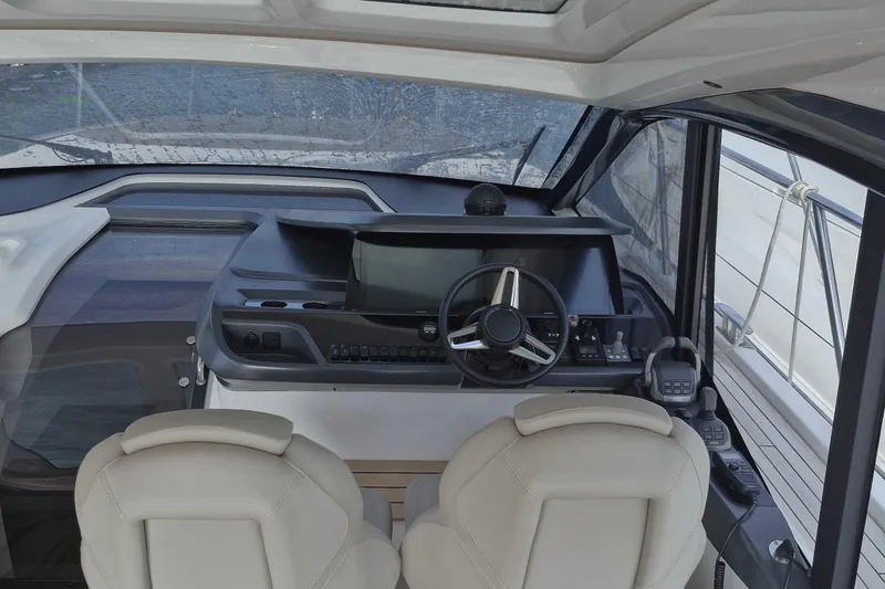  Yacht Photos Pics Interior cockpit of 2024 Princess V50 yacht with modern steering and navigation controls.