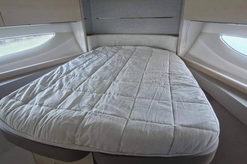  Yacht Photos Pics Luxurious bedroom interior of 2024 Princess V50 yacht with elegant bedding and large windows.