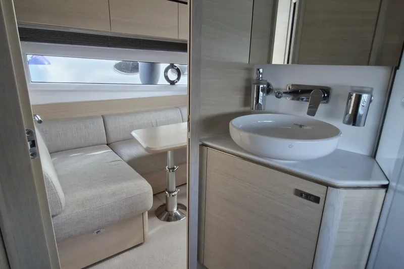  Yacht Photos Pics Modern interior of 2024 Princess V50 yacht with sleek bathroom and cozy seating area.