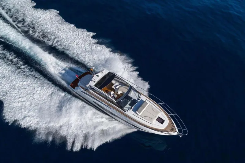  Yacht Photos Pics 2024 Princess V50 yacht cruising on open blue water, creating a dynamic wake.