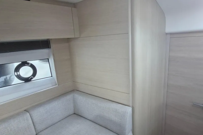  Yacht Photos Pics Interior of 2024 Princess V50 yacht with light wood paneling and a small window.