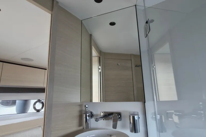  Yacht Photos Pics Modern bathroom interior of 2024 Princess V50 yacht, featuring sleek fixtures and mirror.