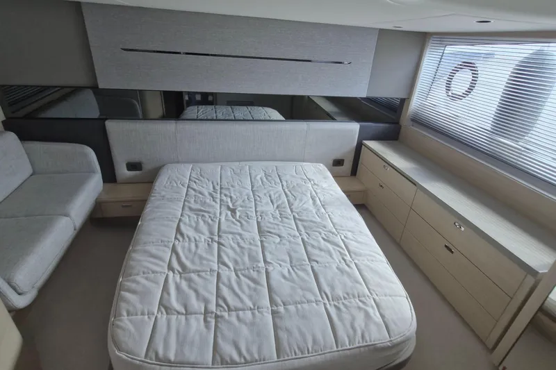  Yacht Photos Pics Luxurious bedroom interior of 2024 Princess V50 yacht with bed and sofa.