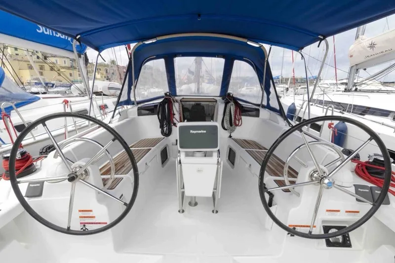  Yacht Photos Pics 2015 Jeanneau Sun Odyssey 409 yacht cockpit with dual steering wheels and blue canopy.
