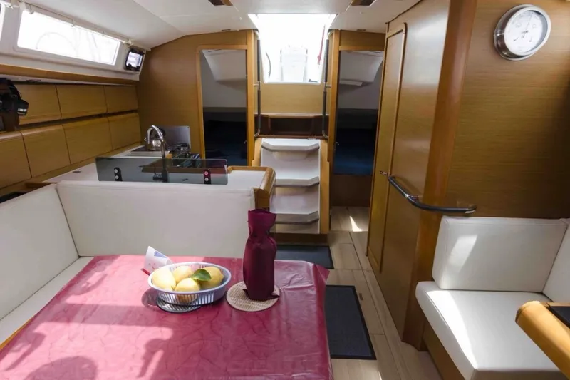  Yacht Photos Pics Interior of 2015 Jeanneau Sun Odyssey 409 sailboat, featuring dining area and kitchen.