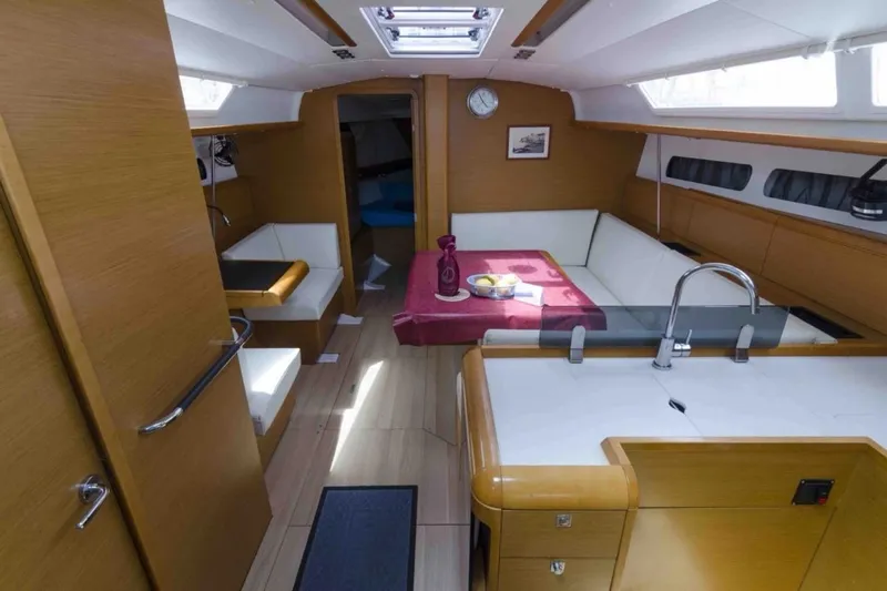  Yacht Photos Pics Interior of 2015 Jeanneau Sun Odyssey 409 yacht with modern wood finish and seating area.