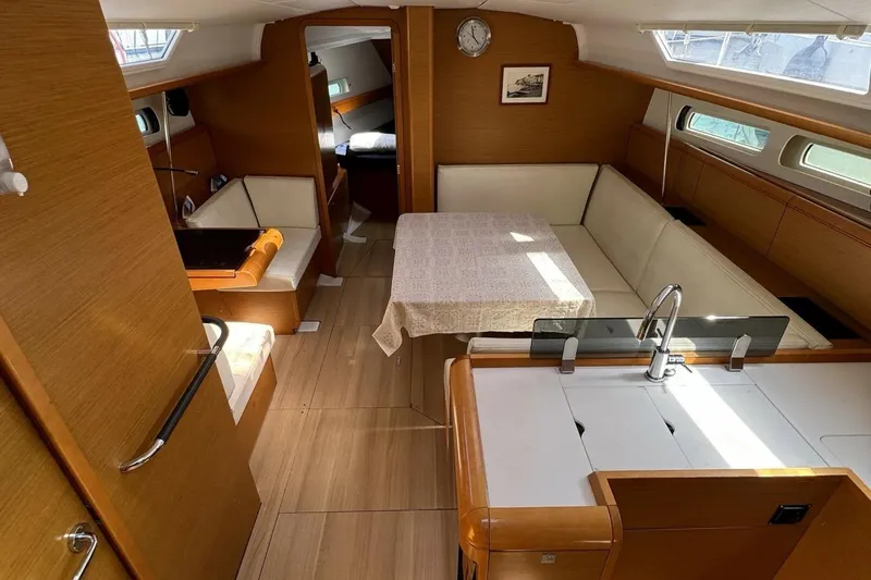  Yacht Photos Pics Interior of 2015 Jeanneau Sun Odyssey 409 yacht with cozy seating and dining area.