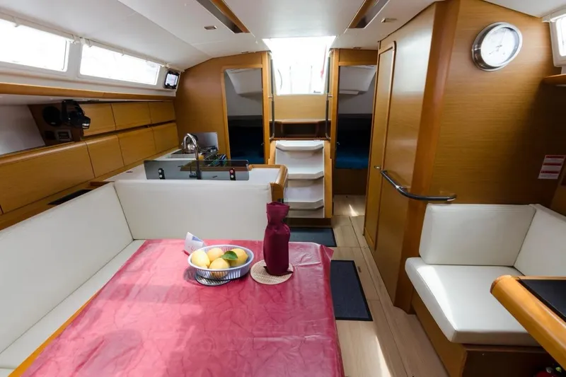  Yacht Photos Pics Interior of 2015 Jeanneau Sun Odyssey 409 sailboat, featuring dining area and modern wood finish.