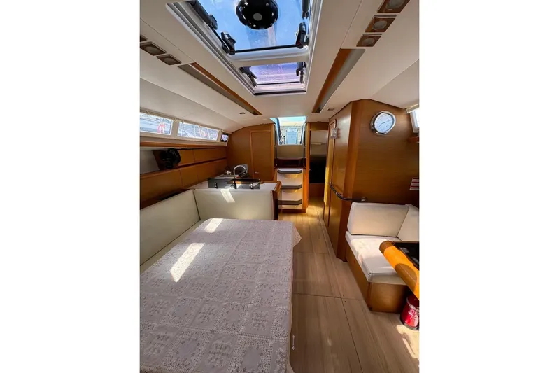  Yacht Photos Pics Interior of 2015 Jeanneau Sun Odyssey 409 sailboat, featuring cozy seating and dining area.