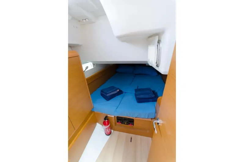  Yacht Photos Pics Cozy cabin interior of 2015 Jeanneau Sun Odyssey 409 sailboat with blue bedding.