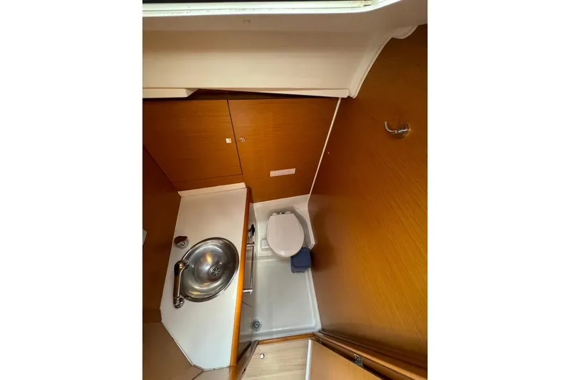  Yacht Photos Pics 2015 Jeanneau Sun Odyssey 409 bathroom with sink and toilet, wooden cabinetry.