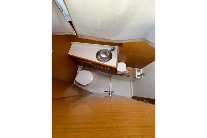  Yacht Photos Pics Bathroom interior of 2015 Jeanneau Sun Odyssey 409 yacht, featuring sink and toilet.