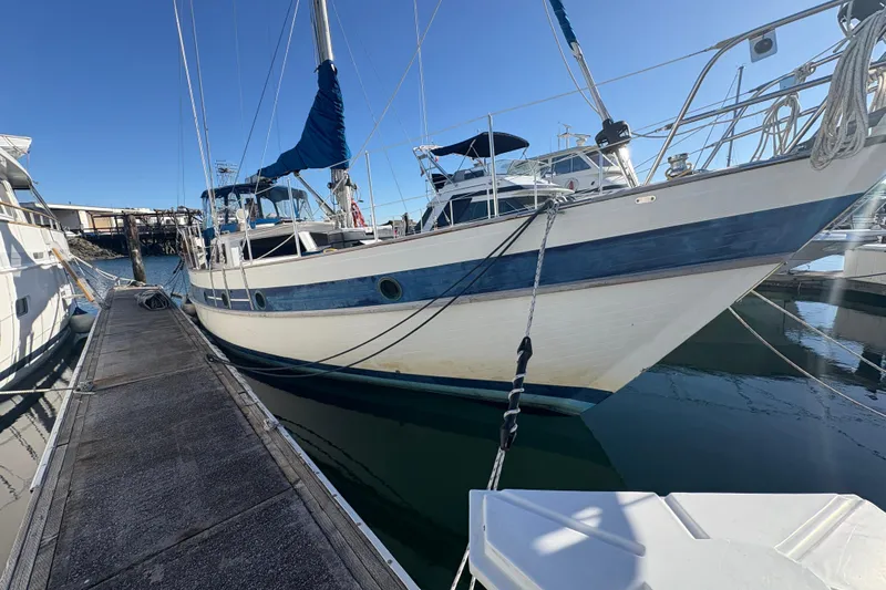 Tenacious Yacht Photos Pics 1987 Mikelson 50 yacht docked at marina, featuring blue and white design.