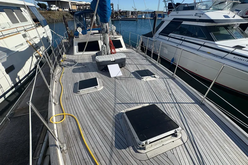 Tenacious Yacht Photos Pics 1987 Mikelson 50 yacht docked, showcasing spacious deck and sleek design.