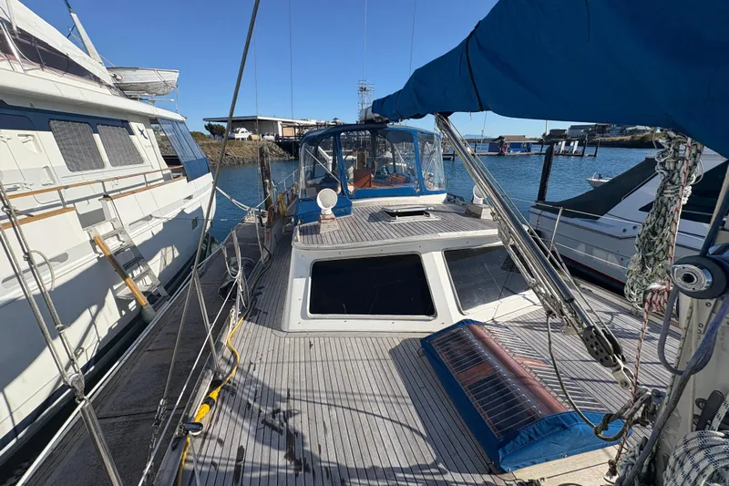 Tenacious Yacht Photos Pics 1987 Mikelson 50 yacht docked at marina, featuring spacious deck and blue canopy.