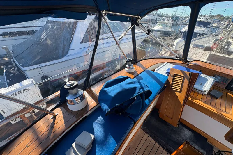 Tenacious Yacht Photos Pics Interior view of a 1987 Mikelson 50 yacht cockpit with marina background.