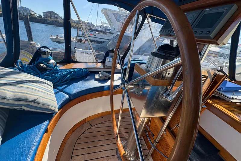 Tenacious Yacht Photos Pics Interior of 1987 Mikelson 50 yacht with wooden steering wheel and nautical equipment.