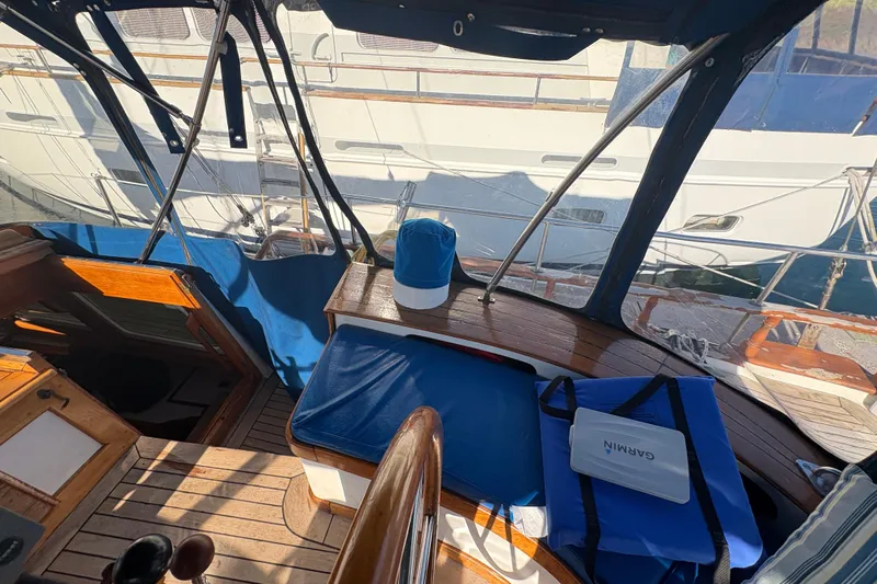 Tenacious Yacht Photos Pics Interior view of a 1987 Mikelson 50 yacht with blue seating and Garmin equipment.