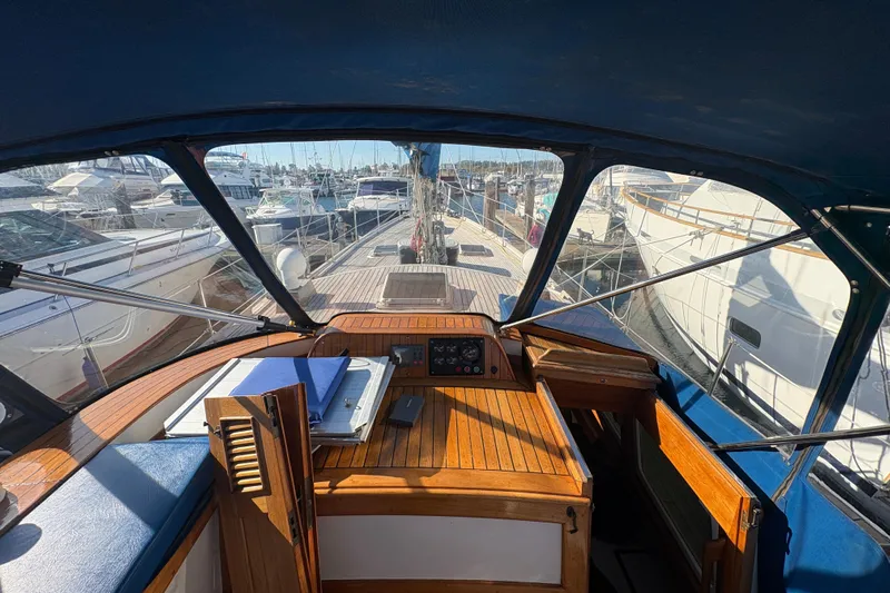 Tenacious Yacht Photos Pics Interior view of 1987 Mikelson 50 yacht cockpit with marina background.
