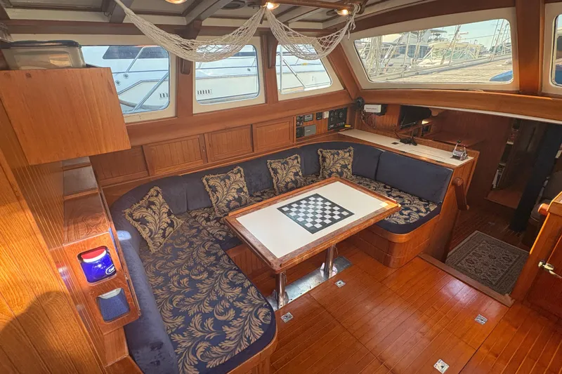 Tenacious Yacht Photos Pics Luxurious interior of a 1987 Mikelson 50 yacht with elegant seating and chess table.