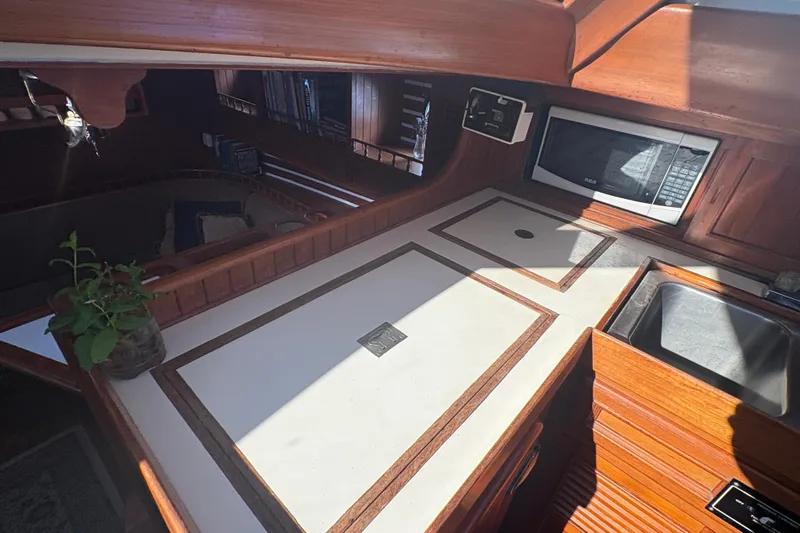 Tenacious Yacht Photos Pics Interior of 1987 Mikelson 50 yacht kitchen with wooden cabinetry and modern appliances.