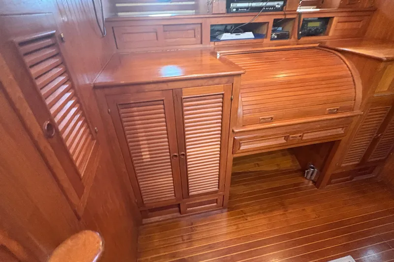 Tenacious Yacht Photos Pics Wooden interior of a 1987 Mikelson 50 yacht with cabinets and roll-top desk.