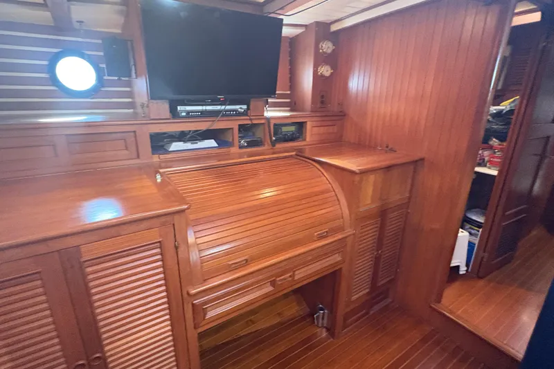 Tenacious Yacht Photos Pics Interior of 1987 Mikelson 50 yacht with wooden cabinetry and TV.