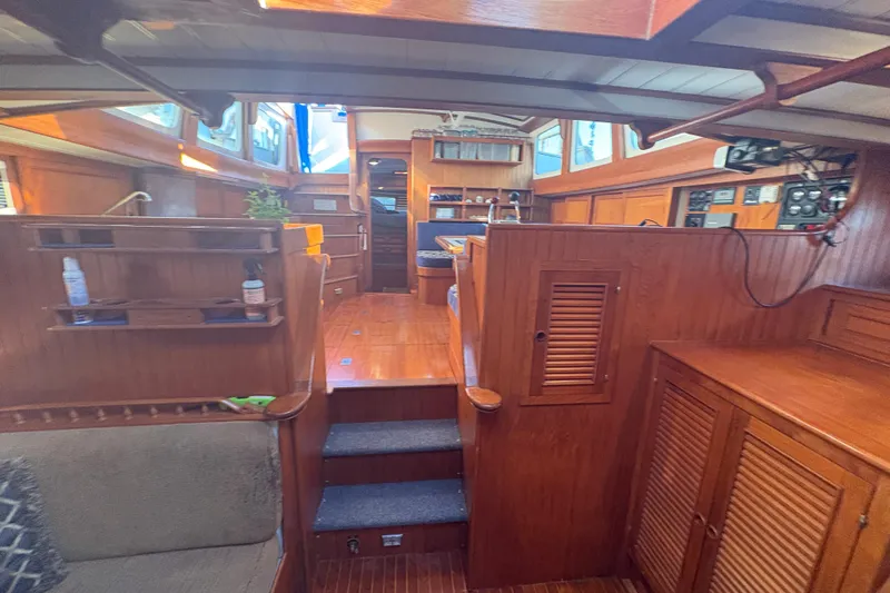 Tenacious Yacht Photos Pics Interior of a 1987 Mikelson 50 yacht with wooden furnishings and cozy seating.