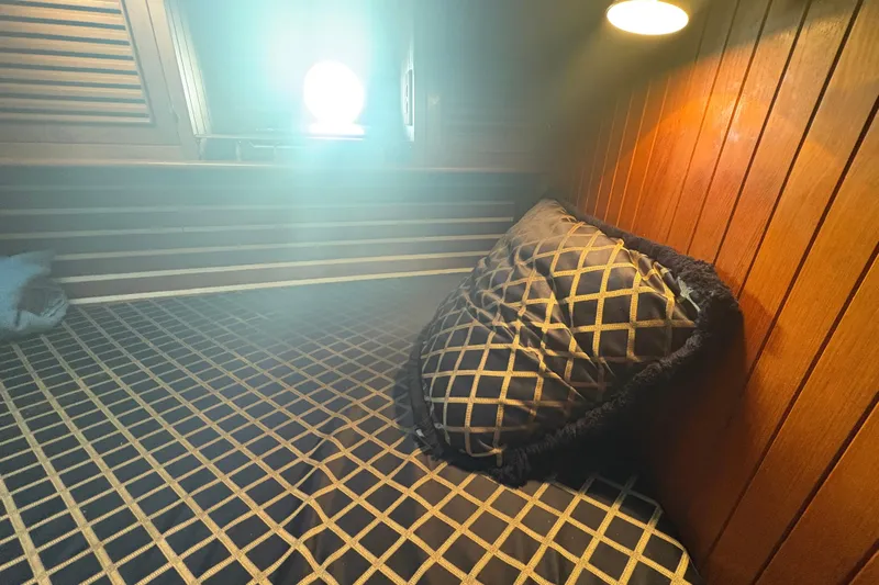 Tenacious Yacht Photos Pics Cozy cabin interior of 1987 Mikelson 50 yacht with wooden paneling and patterned bedding.