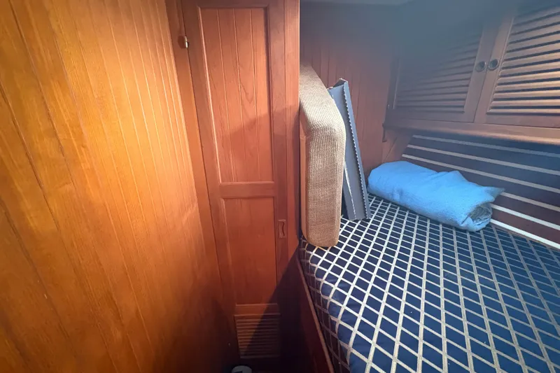 Tenacious Yacht Photos Pics Cozy cabin interior of 1987 Mikelson 50 yacht with wooden paneling and bed.