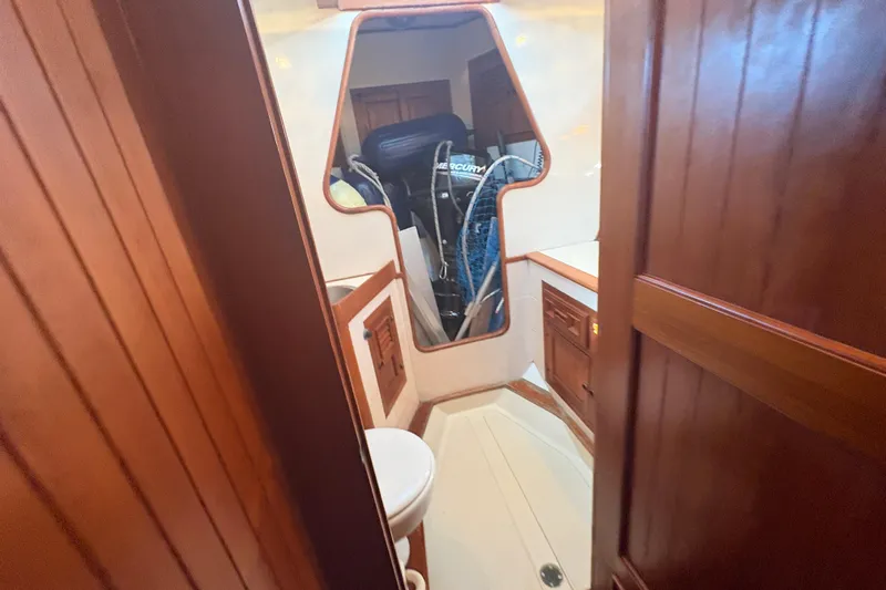 Tenacious Yacht Photos Pics 1987 Mikelson 50 yacht interior with wooden cabinetry and compact bathroom.