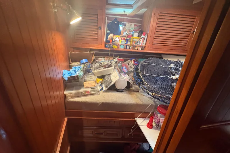 Tenacious Yacht Photos Pics Interior of 1987 Mikelson 50 boat with cluttered storage and fishing gear.