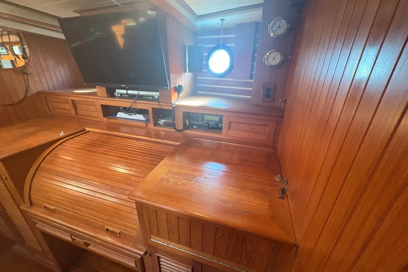 Tenacious Yacht Photos Pics 1987 Mikelson 50 yacht interior with wood paneling, TV, and nautical instruments.