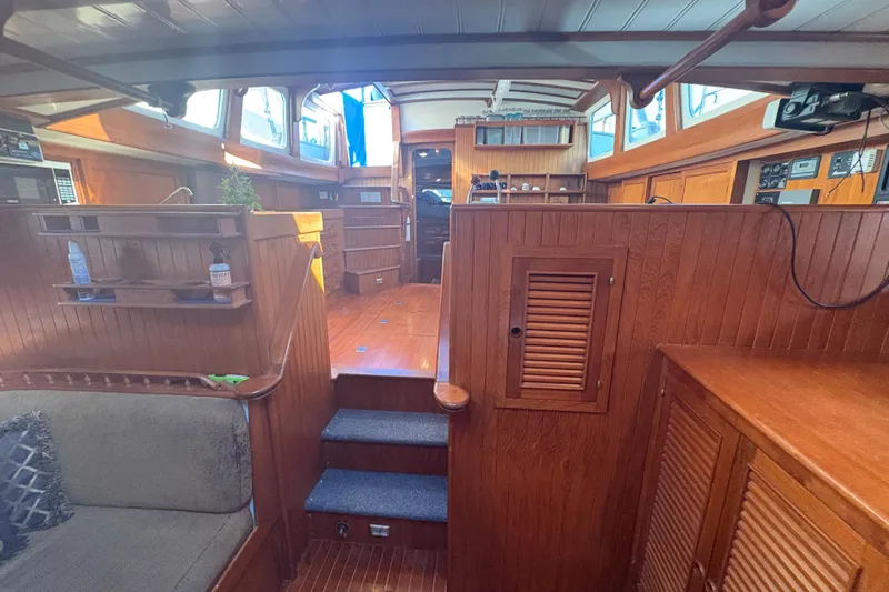 Tenacious Yacht Photos Pics Interior of 1987 Mikelson 50 yacht with wooden paneling and cozy seating area.