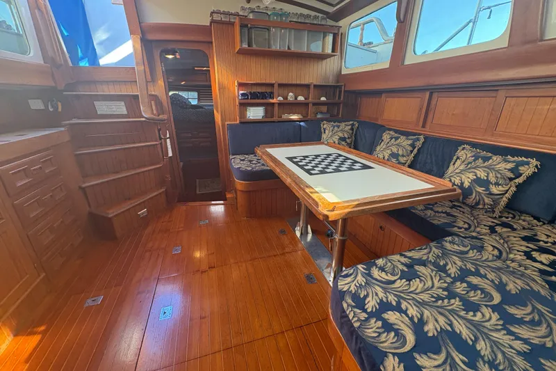 Tenacious Yacht Photos Pics Luxurious 1987 Mikelson 50 yacht interior with elegant wood finish and plush seating.